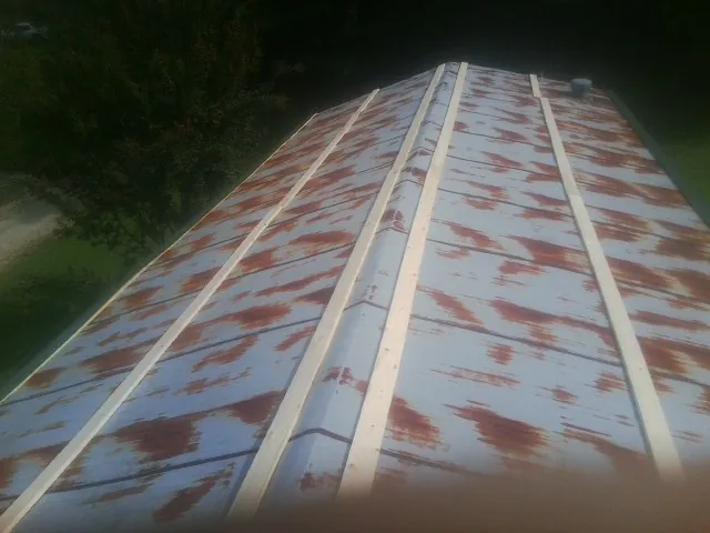 Rusted metal roof panels with new wood purlins before replacement — Storm Damage Roof Repair in Carol Stream by Roofing Brothers